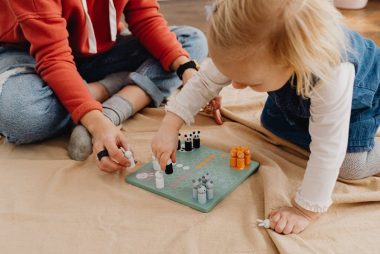 A mother and daughter bonding over a board game indoors, capturing family fun and togetherness.